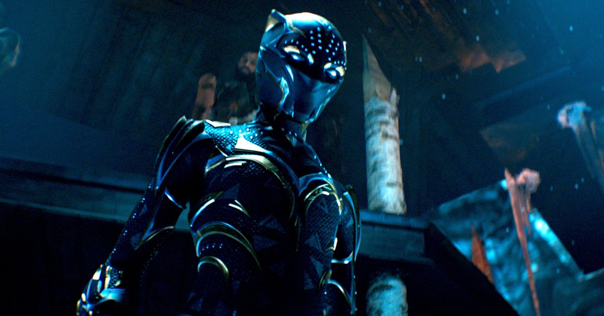 Shuri in her gold-streaked Black Panther suit, standing in a dark throne room, in Black Panther: Wakanda Forever