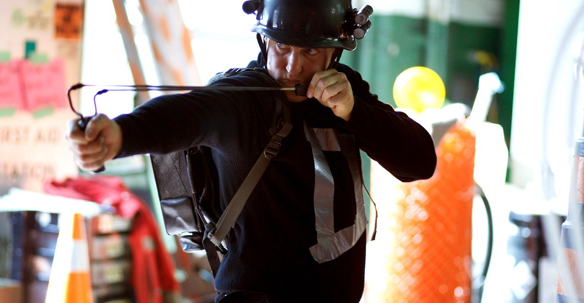 Woody Harrelson, wearing a goofy-looking helmet, readies a slingshot as the vigilante Defendor in Defendor