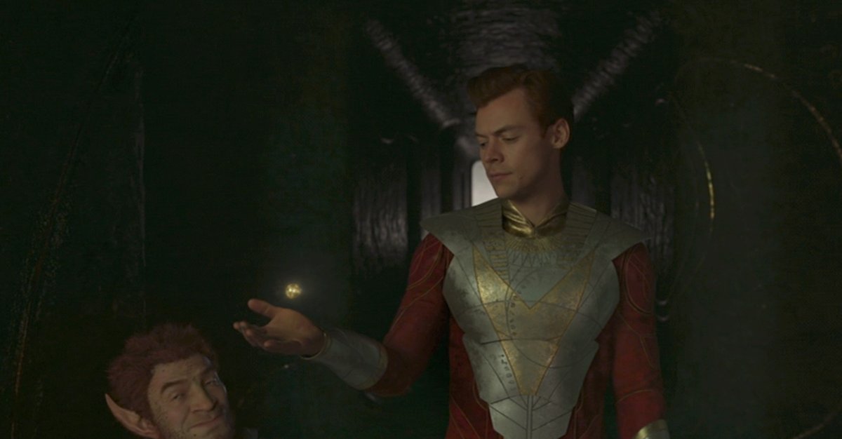 Eros (Harry Styles) contemplates an orb next to Pip the Troll in a shot from Eternals